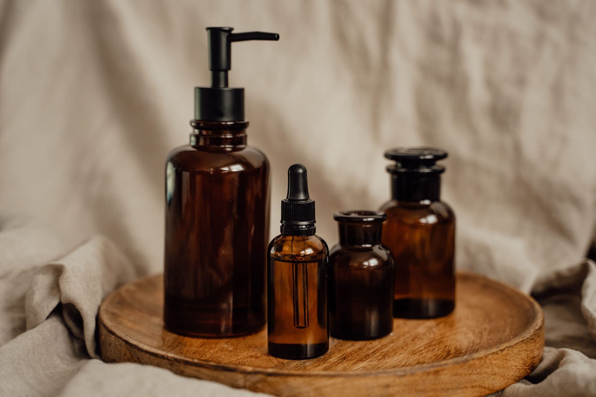 Brown glass cosmetic bottles with droppers on a dark surface