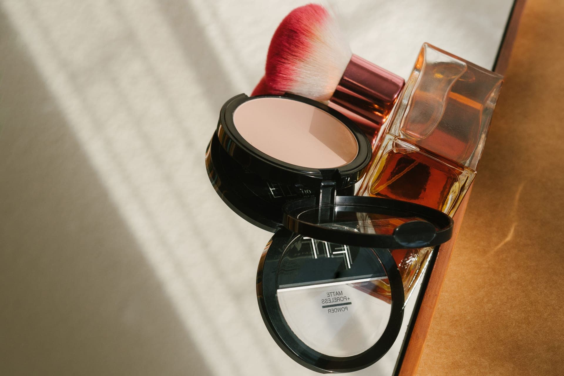 A makeup setting spray bottle beside a loose powder pot
