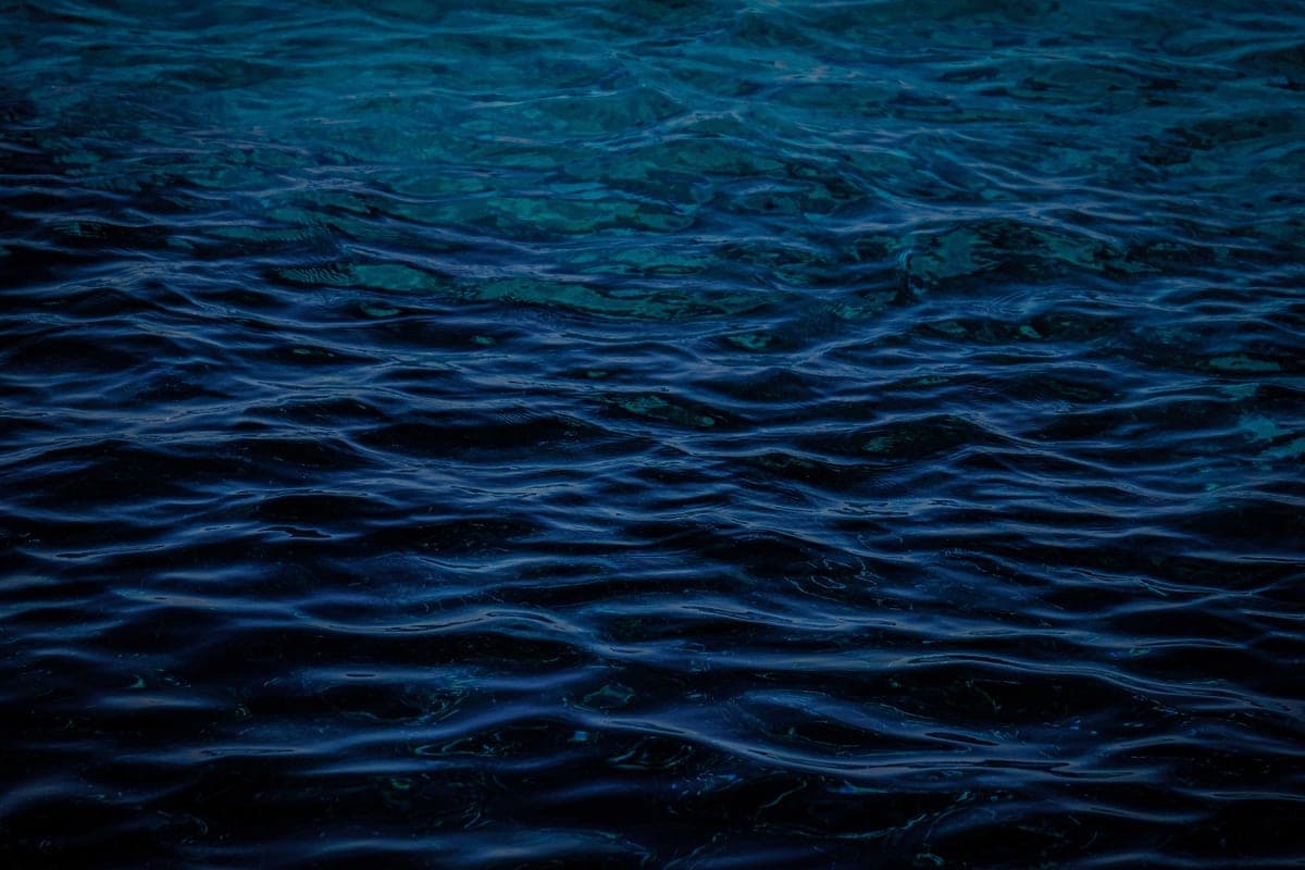 Dark seawater with a breaking wave, minimal and low-lit