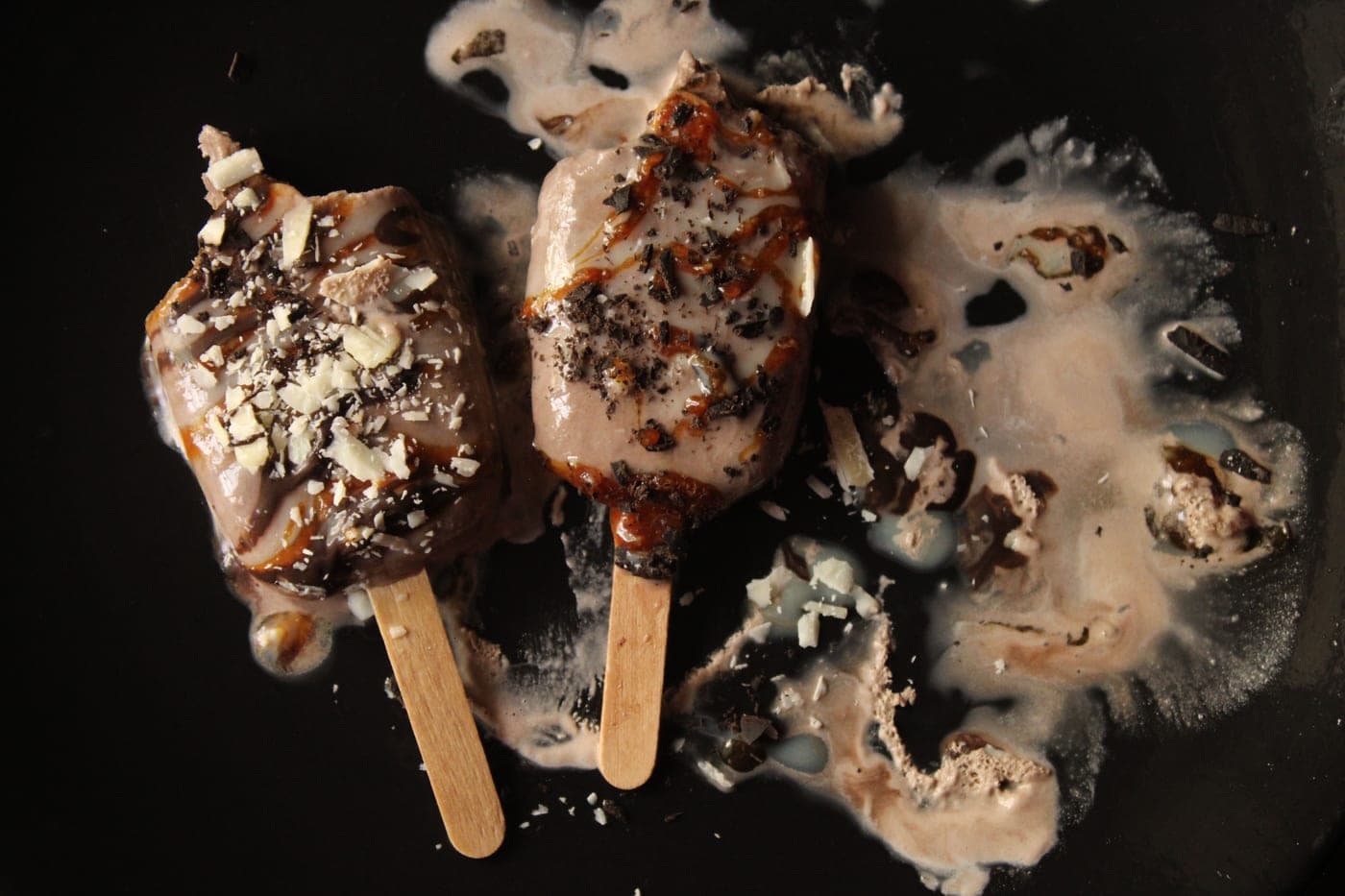 Vanilla pods and caramel photographed on a dark surface