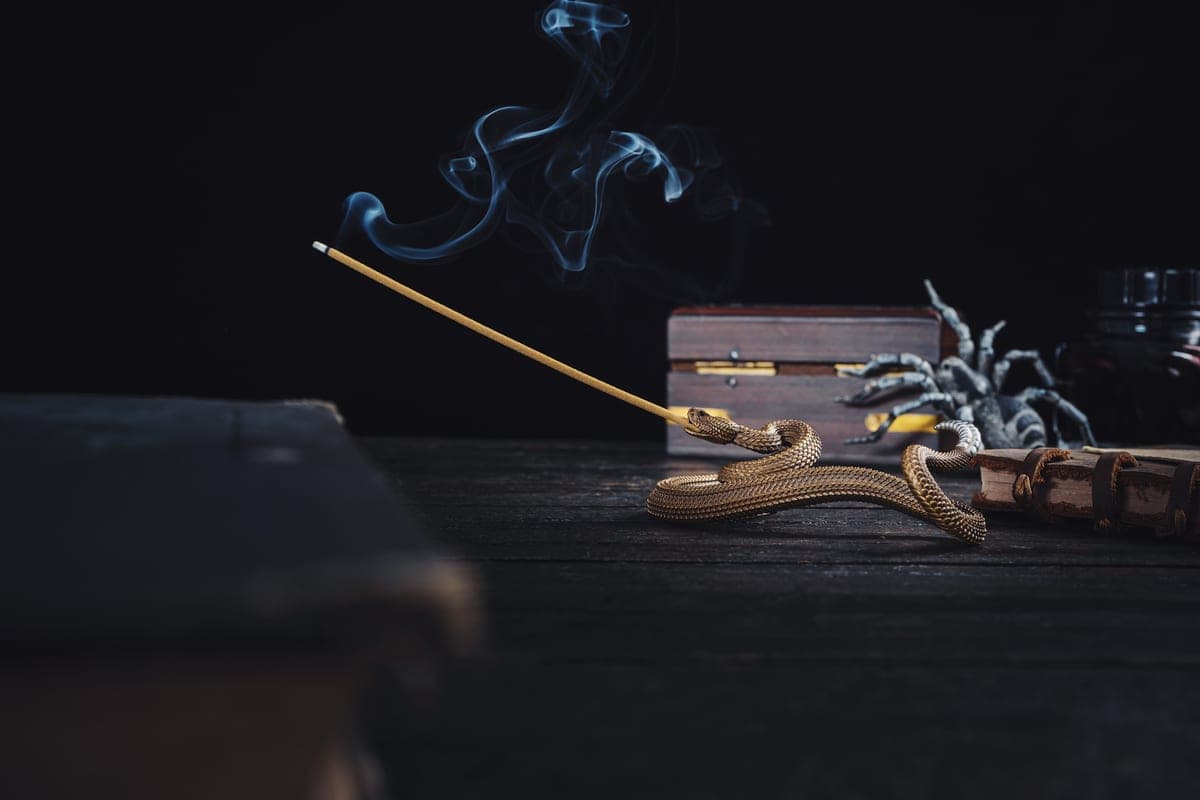 Incense smoke rising against a dark background