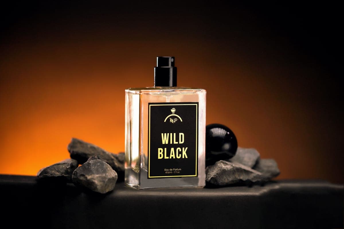 A tall elegant perfume bottle photographed dramatically in low light