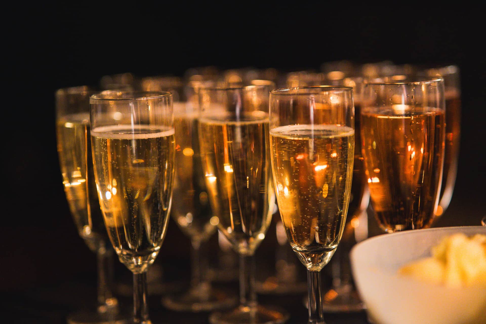 Rows of champagne glasses with rising bubbles