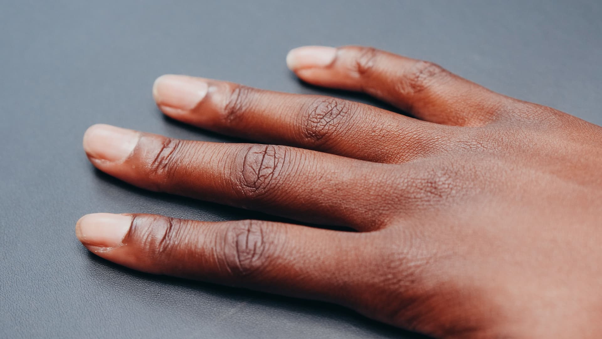 A hand resting on a gray surface