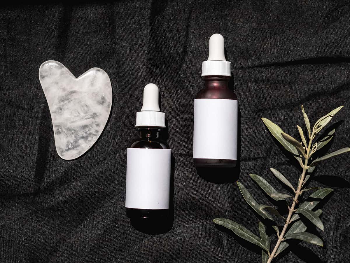 Skincare bottles lined up along a dark shelf