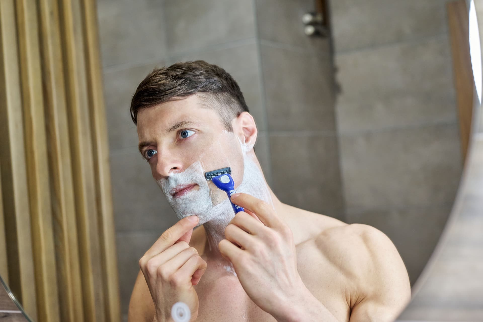 A man shaving in front of a mirror