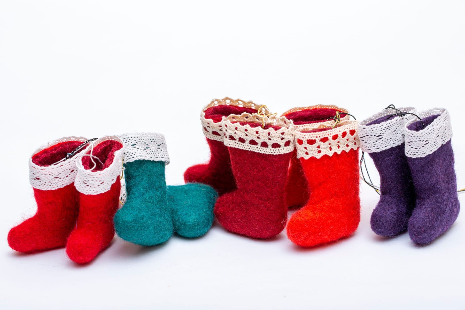 Small felt stockings with lace trim arranged on a dark surface
