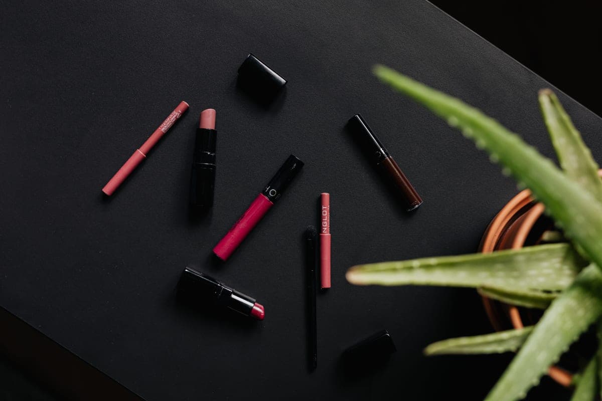 Makeup products arranged on a dark surface in low light