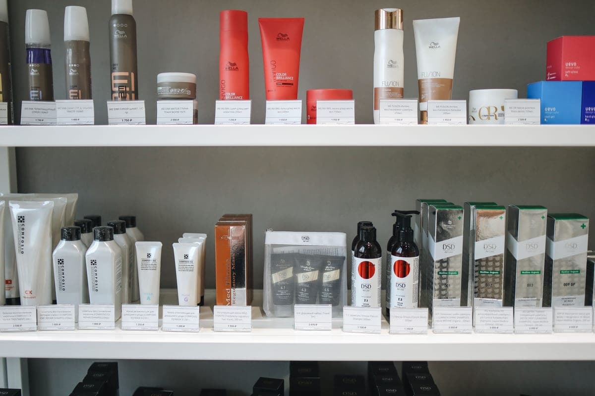 A collection of skincare products arranged on a dark shelf in low light