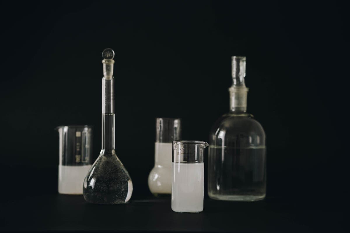 Glass bottle of a clear exfoliating liquid on a dark surface