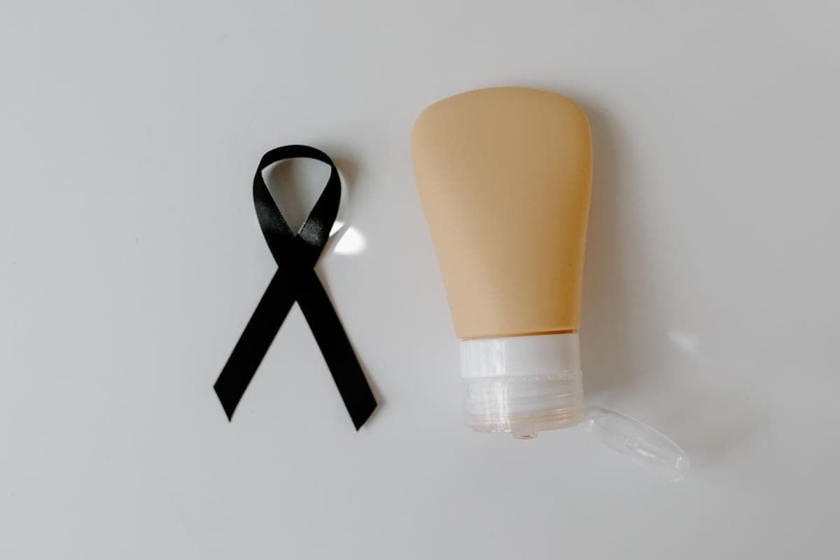 A tube of mineral sunscreen resting on dark stone