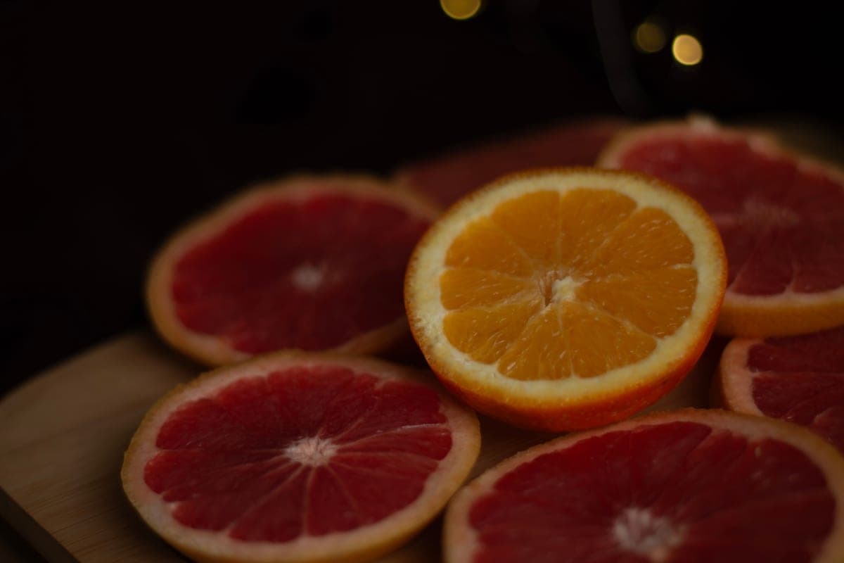 Cut citrus fruit on a dark background lit from the side