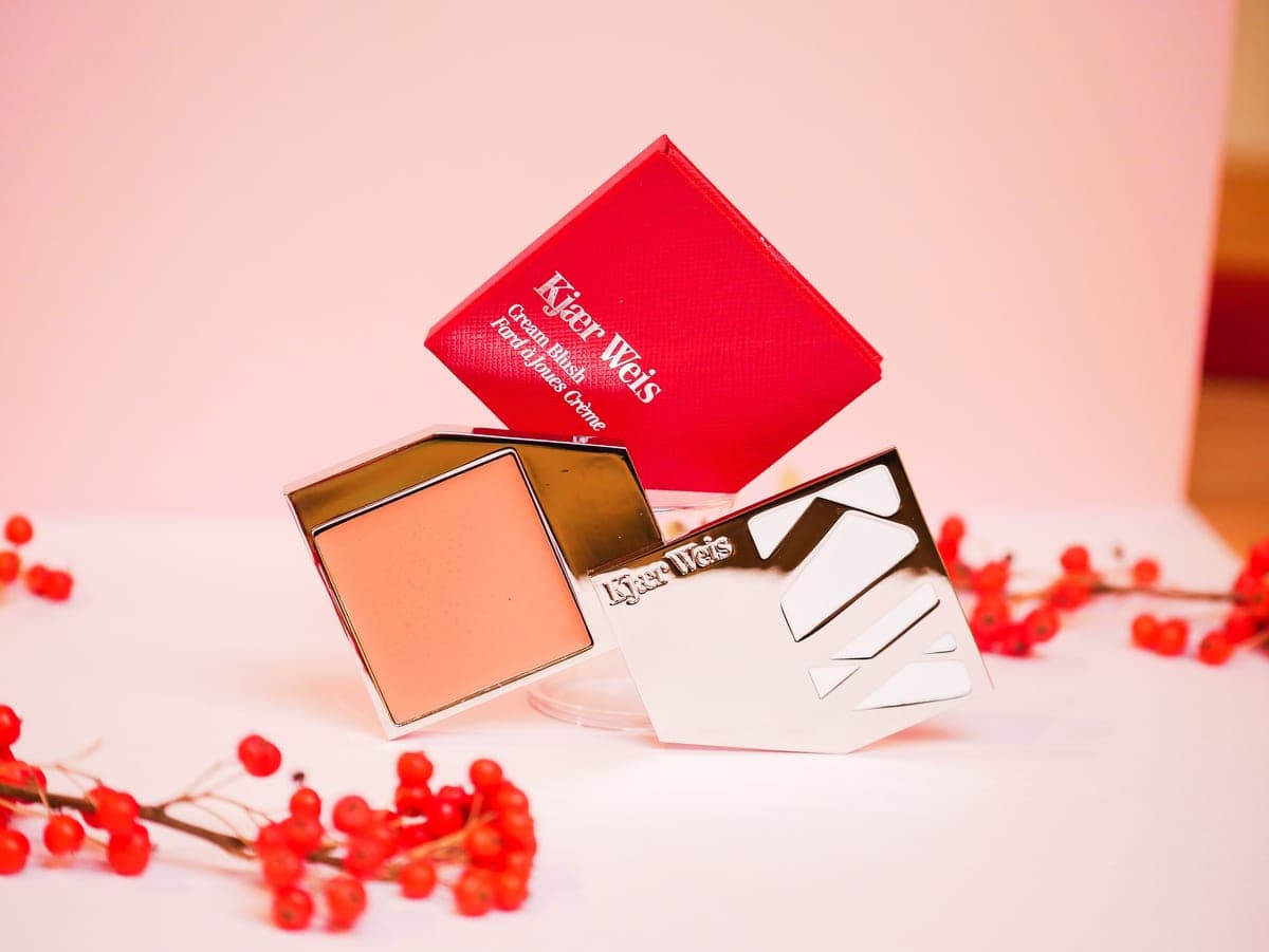 A pot of cream blush on a dark surface