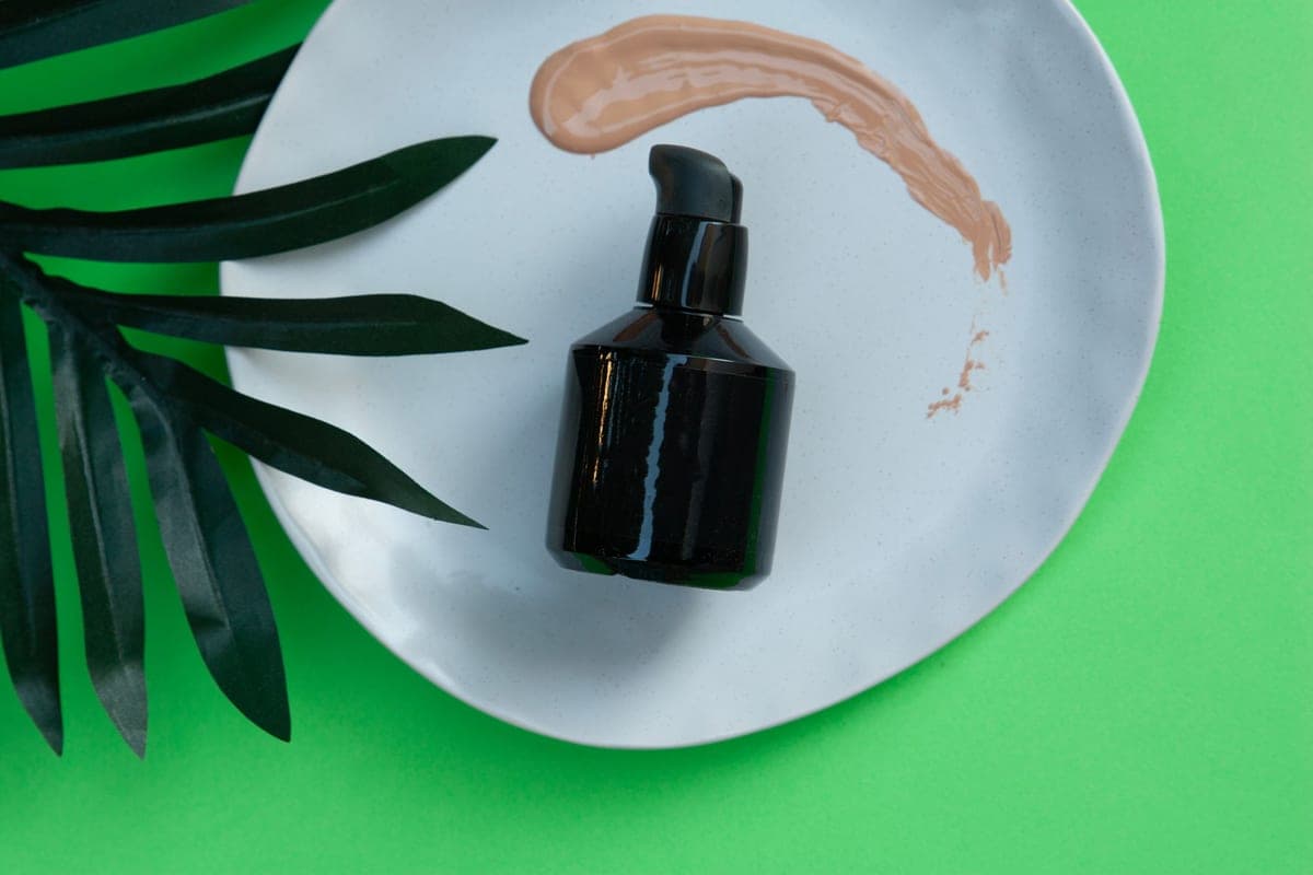 Minimal makeup products arranged on a dark surface