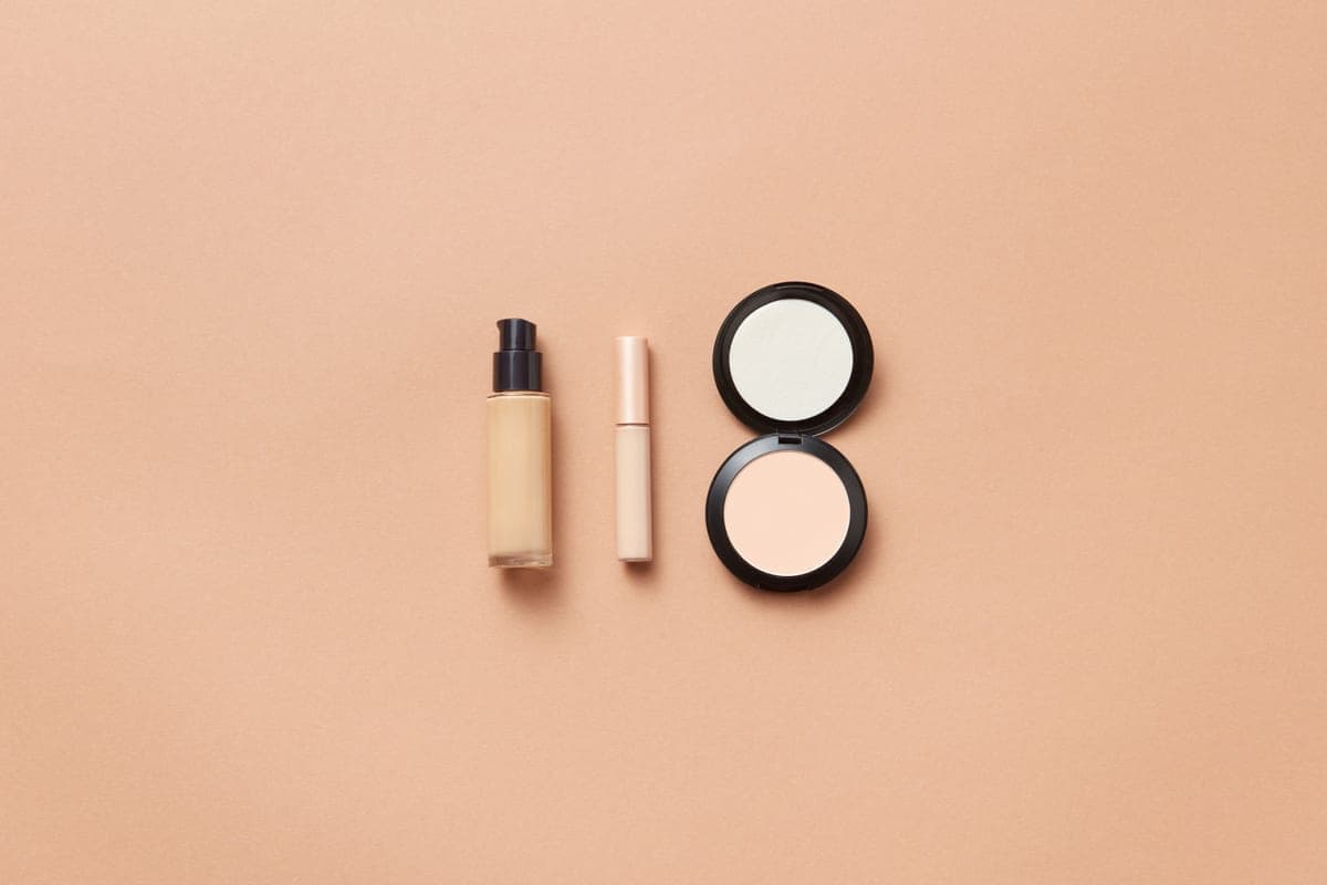 A concealer tube on a dark surface with directional light