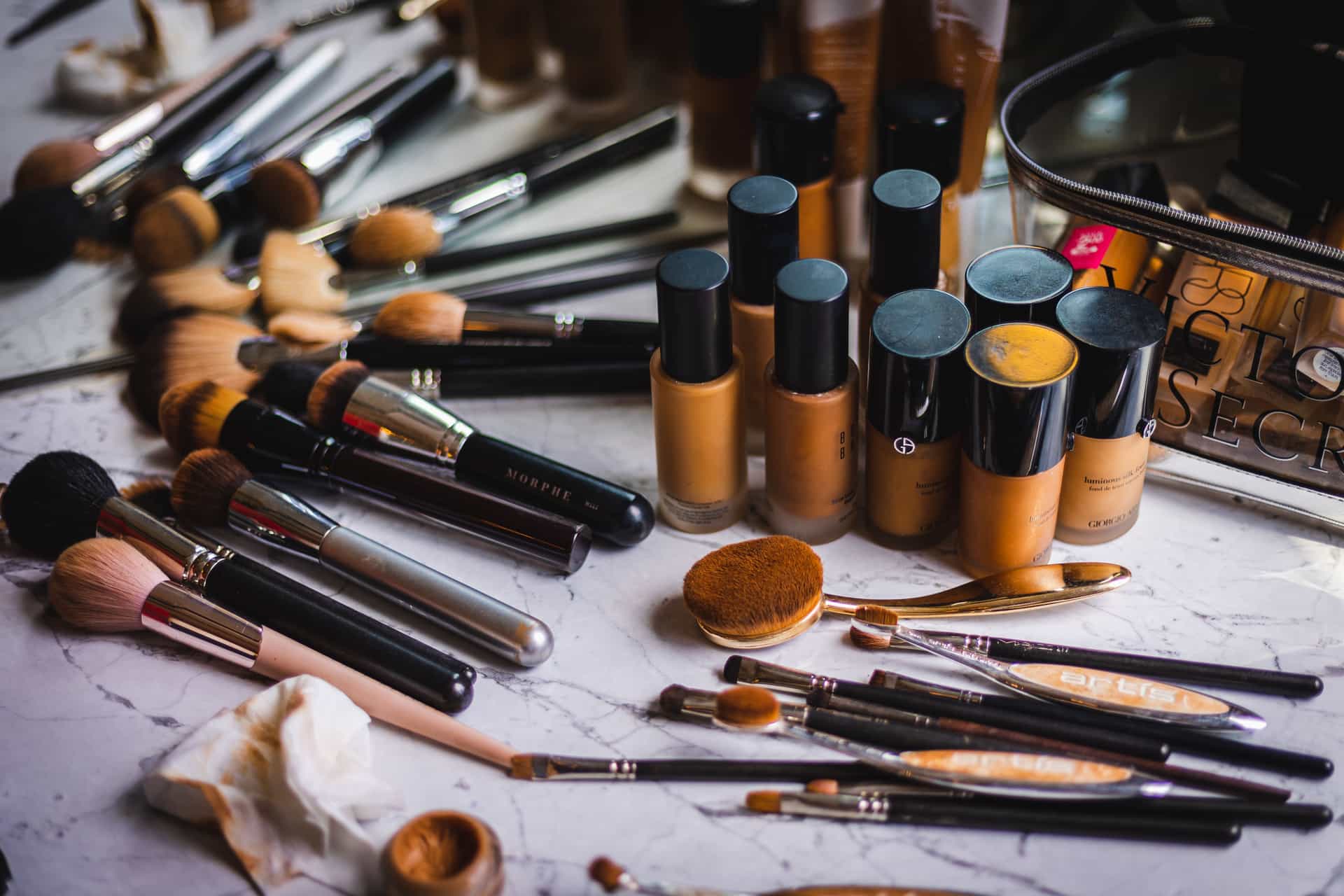 Rows of foundation bottles and makeup brushes