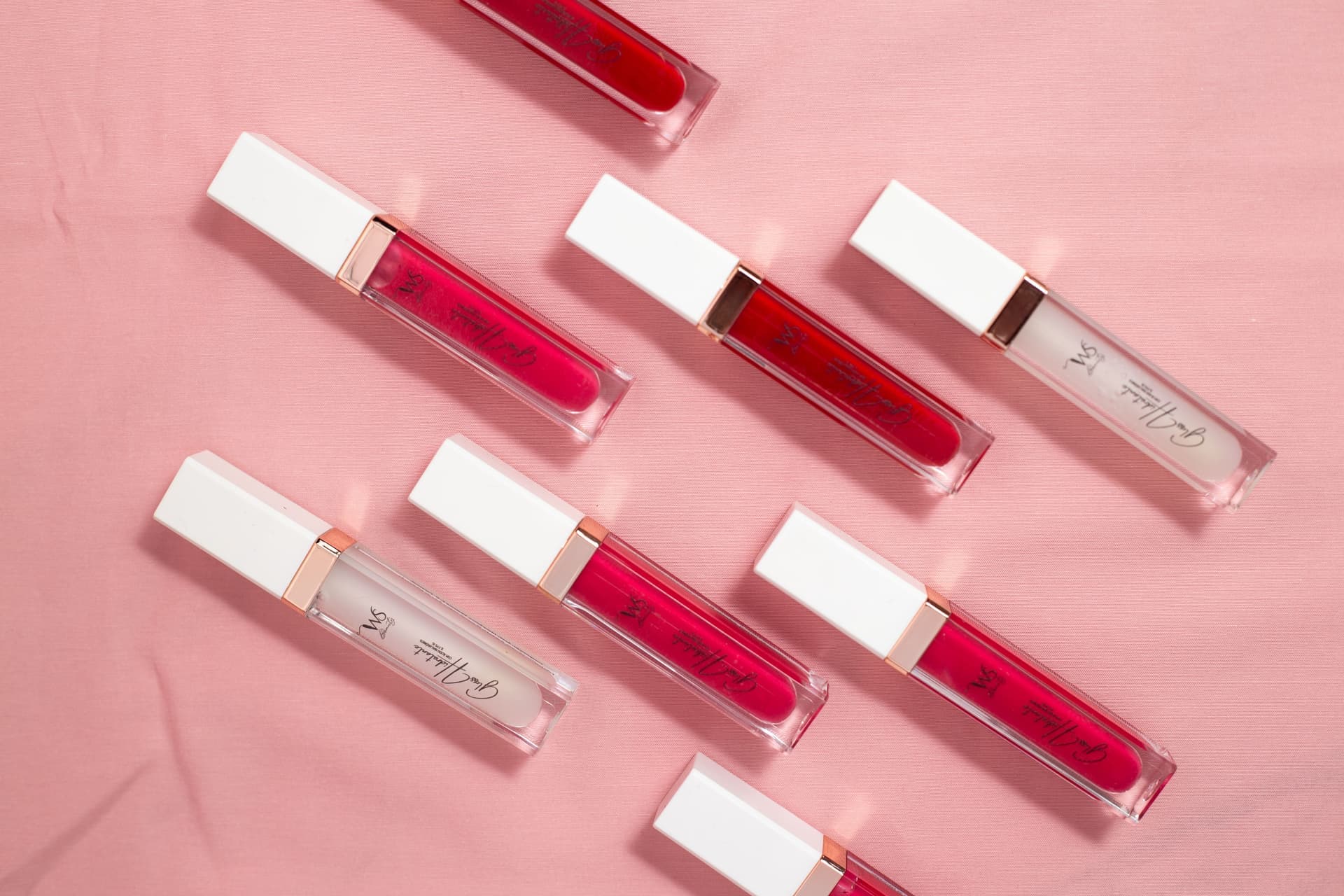 A lip gloss tube on a dark reflective surface
