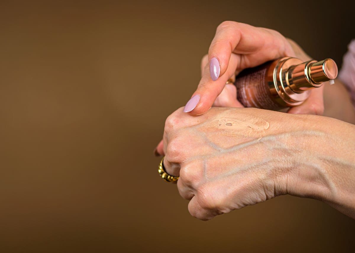A bottle of tinted moisturizer on a dark surface