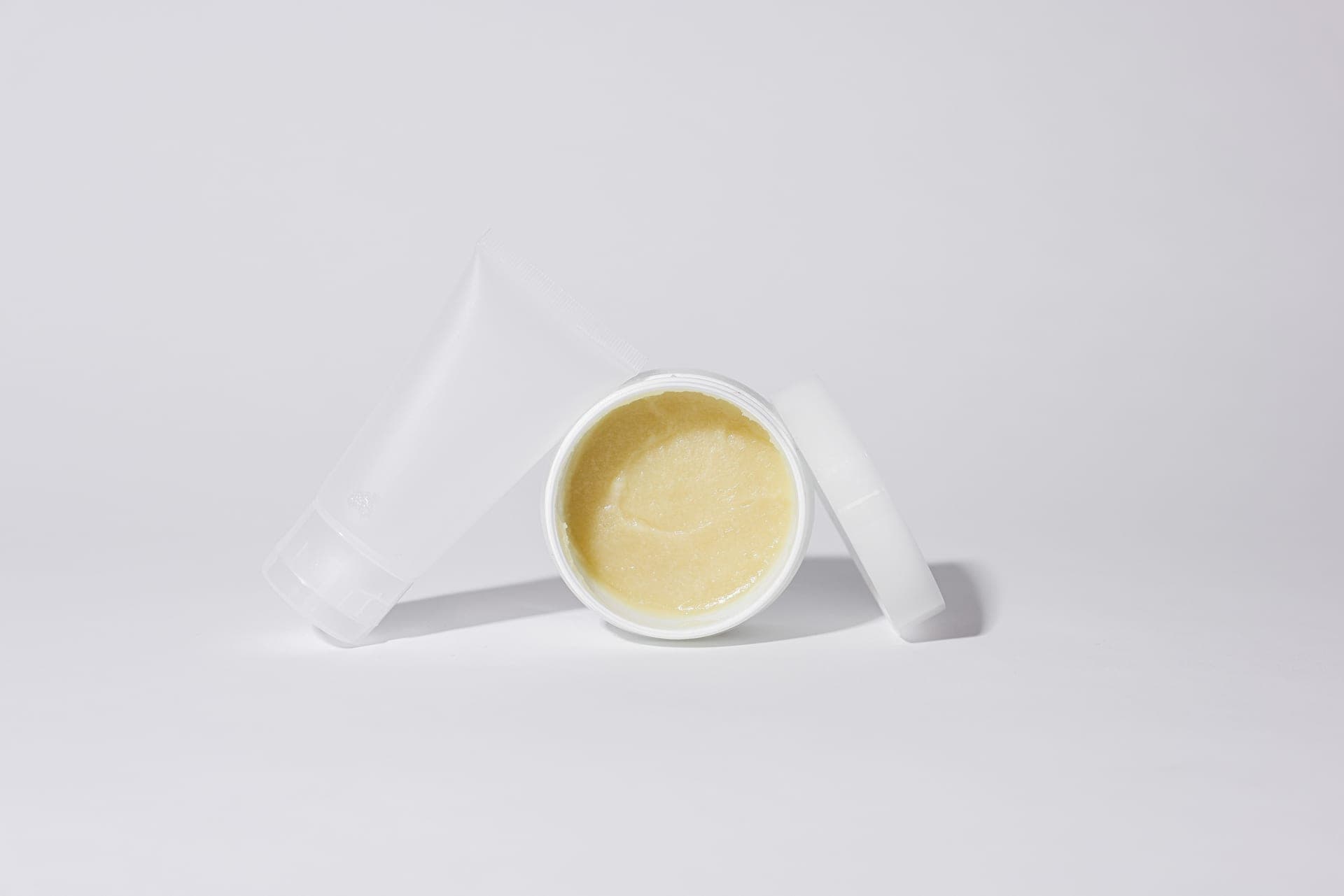 An open jar of cleansing balm beside a tube