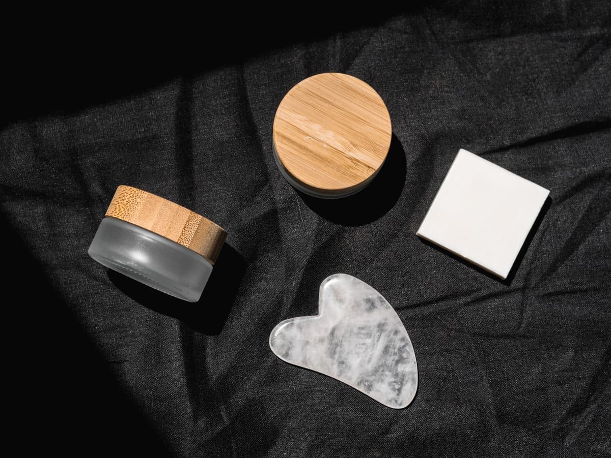 A jar of rich face cream photographed on a dark surface