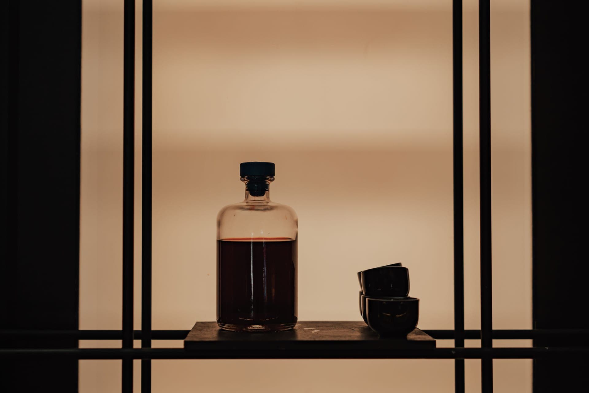 A clear glass bottle of toner on a dark moody surface