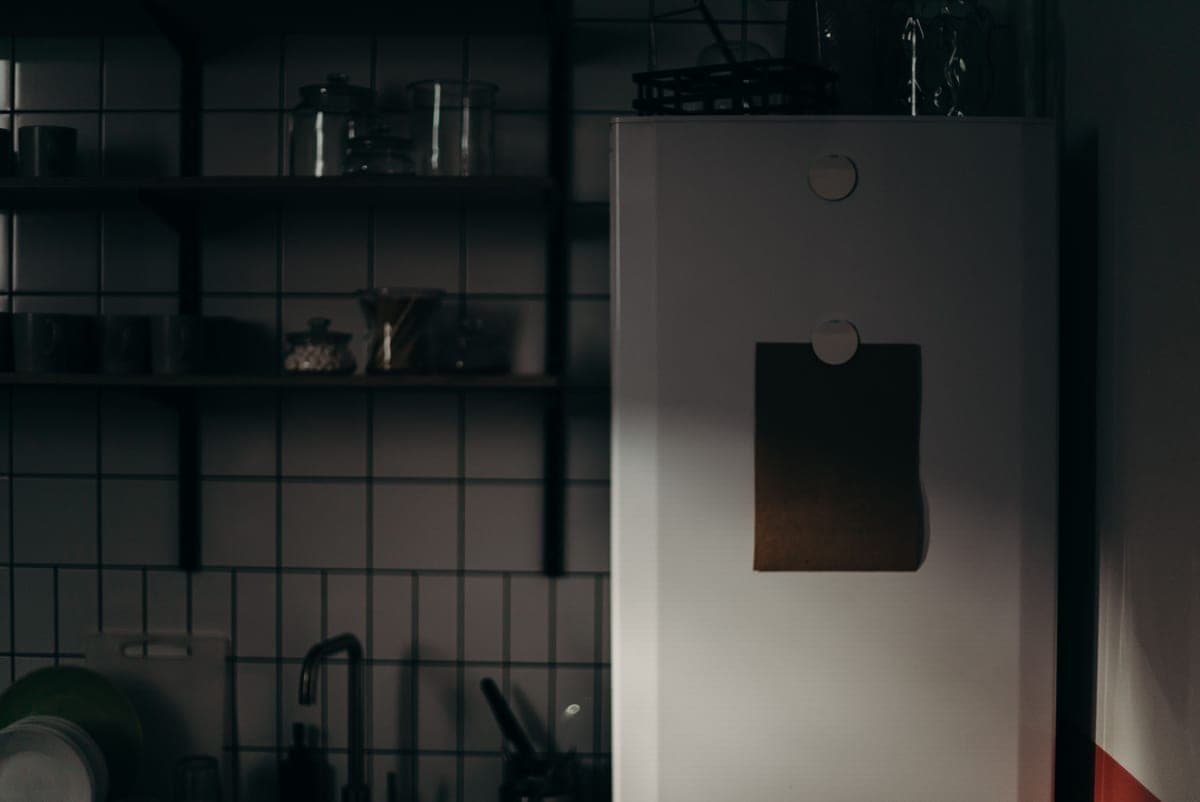 A small refrigerator appliance in a dark minimal setting